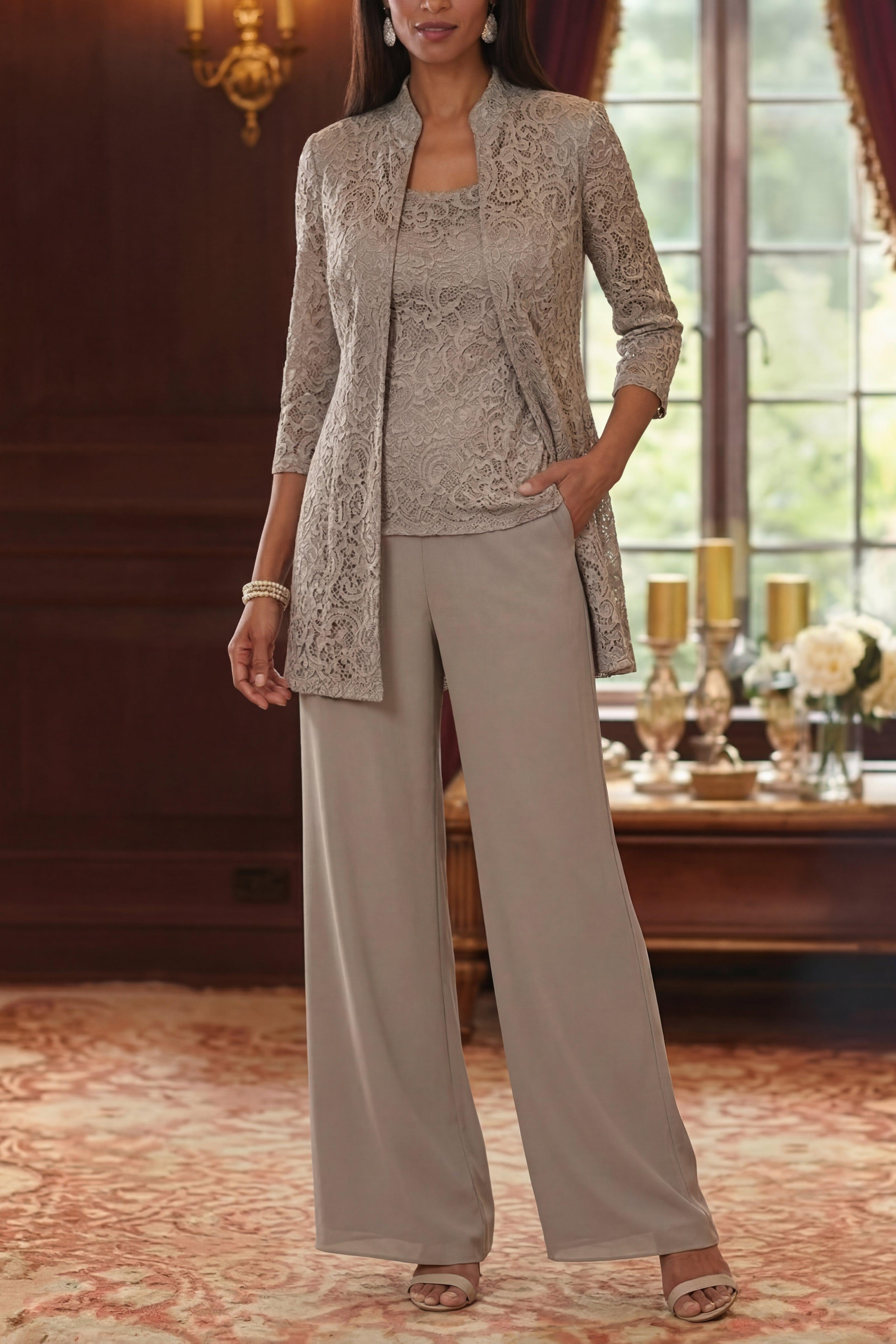 Woman wearing a gray lace jacket and pants in an elegant room with a table and decorative items.
