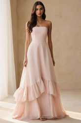 Front view of the light pink strapless chiffon A-line prom dress with a structured bodice and tiered ruffle hem