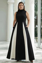 Plus size model wearing a black and white high neck satin A-line prom dress with side pockets