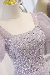 Close-up of the square neck bodice covered in sequins and beads beside a sheer puff sleeve