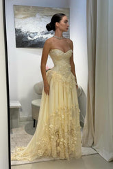 Yellow A-line prom dress with strapless sweetheart bodice and 3D floral lace, shown in a side standing view