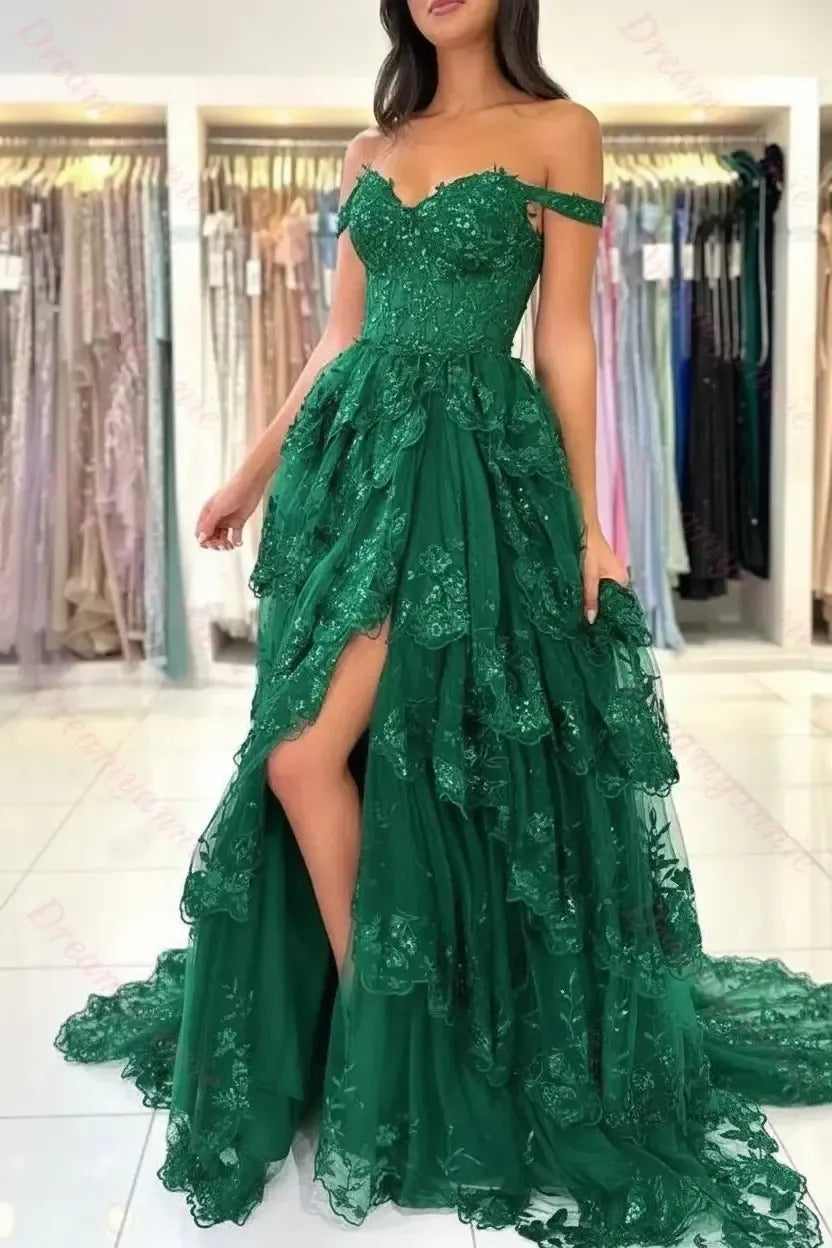 Emerald green off-the-shoulder bridal dress featuring tiered lace, a sweetheart neckline, and a high-slit tulle skirt.