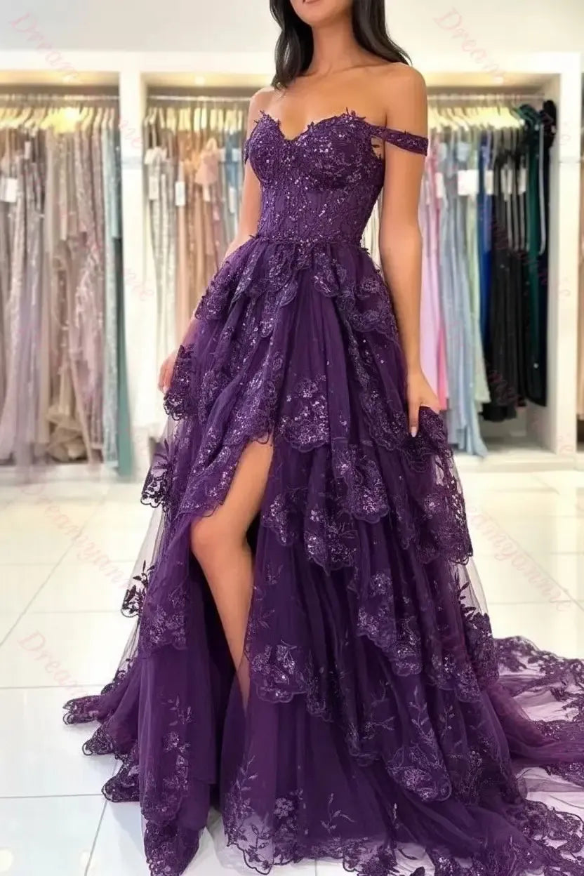 Off-the-shoulder purple lace bridal dress with a tiered tulle skirt, sequin bodice, and high leg slit.