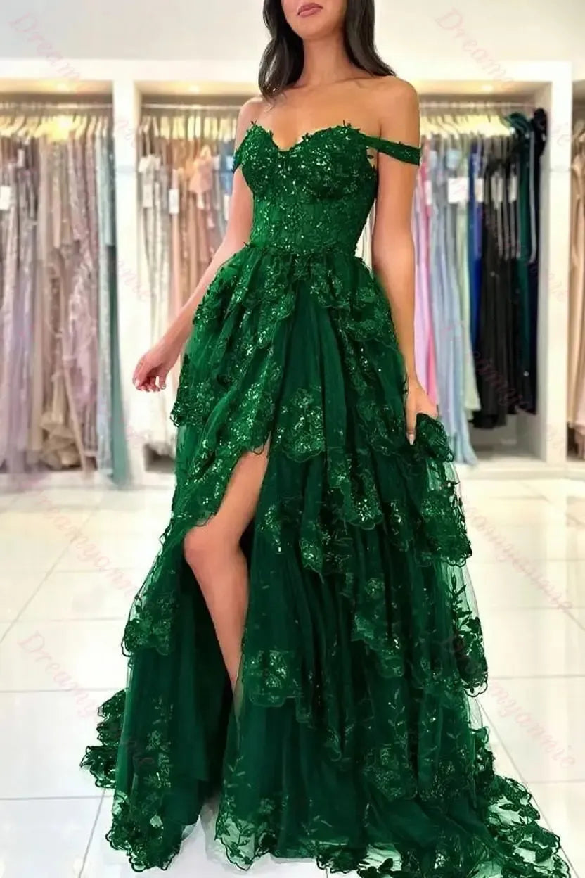 Emerald green off-the-shoulder bridal dress featuring tiered lace, sequin embellishments, and a high-slit tulle skirt.