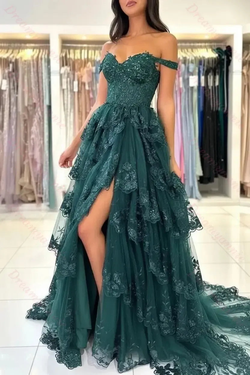 Dark emerald green off-the-shoulder bridal gown featuring tiered lace, tulle layers, and a high leg slit.