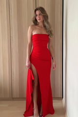 Red satin strapless mermaid prom dress with ruched bodice, shown full length in an indoor setting