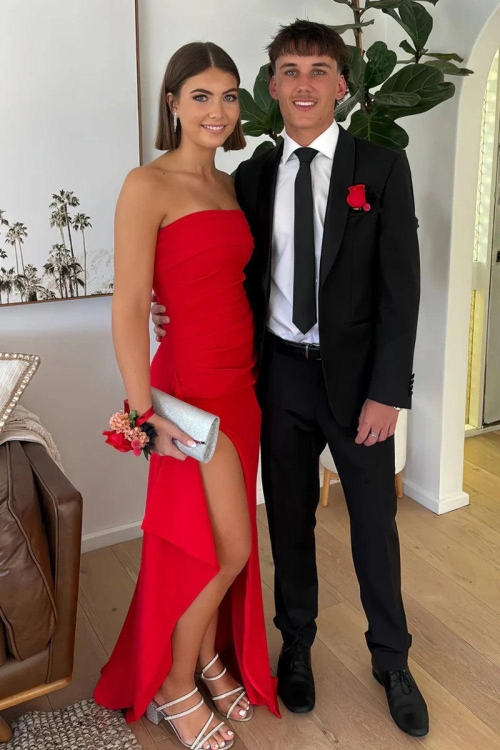 Indoor prom photo of the red satin mermaid dress with ruched bodice and thigh-high slit