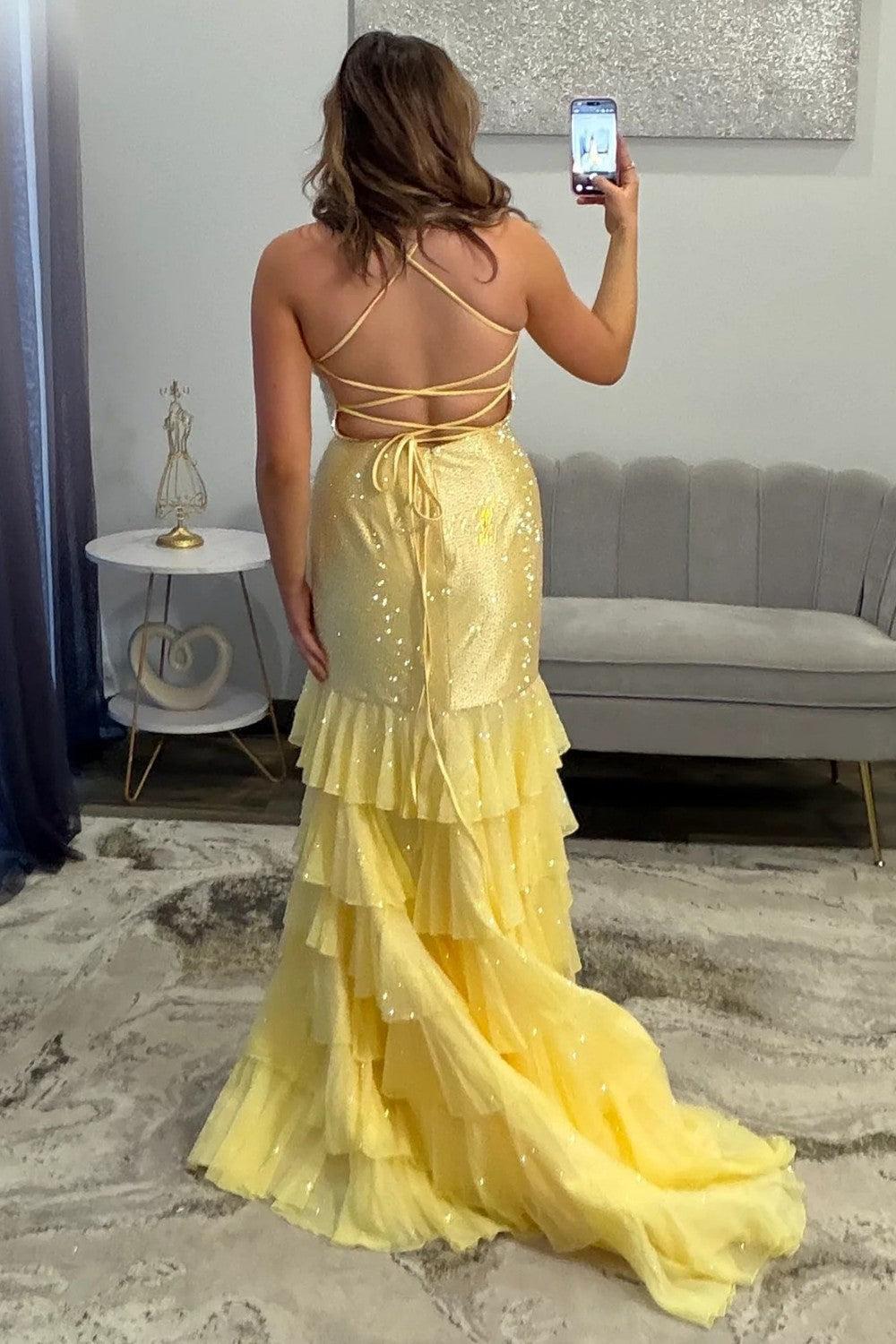 Back view of the yellow prom dress showing the lace-up back and ruffle train