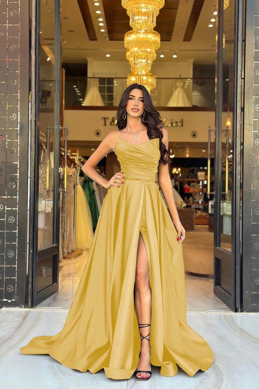 Gold strapless satin A-line prom dress with ruched bodice and pleated skirt with high slit